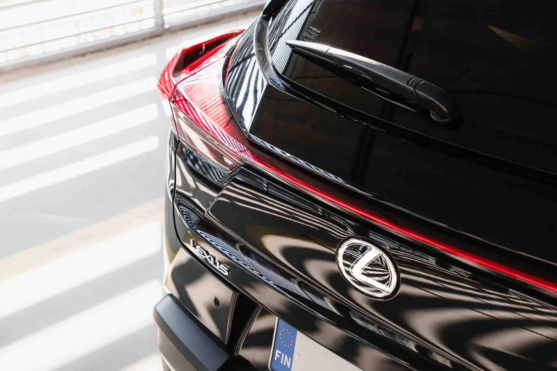 Lähikuva Lexus UX 250h:n takaa, kuvassa korostuu ajovalon muotoilu ja linjat.