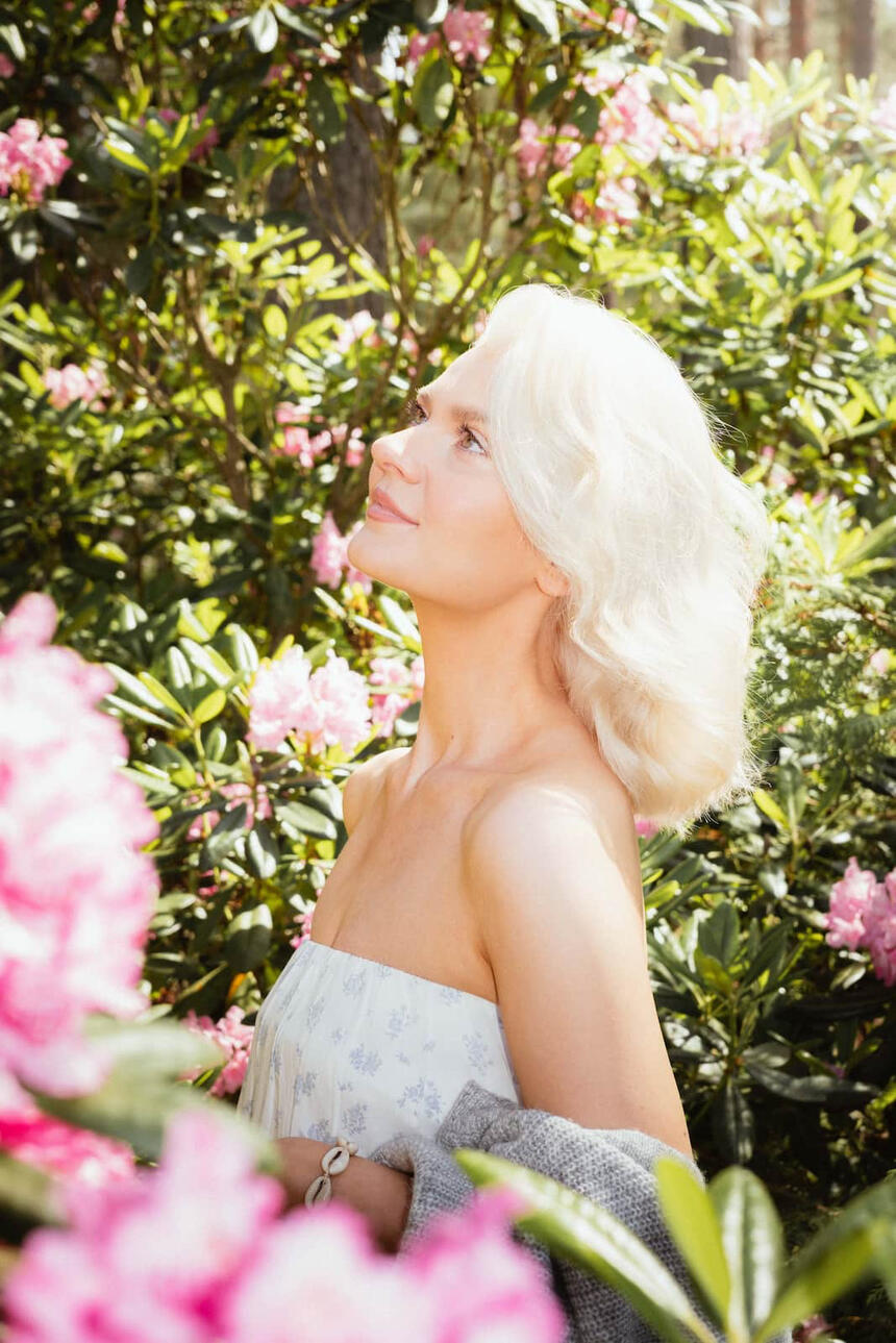 Portrettikuva mallista joka katsoo yläviistoon alppiruusupuutarhassa.